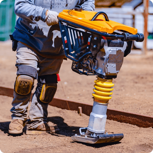 Side view of jumping jack tamper in use