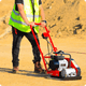 Side view of compact vibratory tamper on gravel