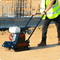 Side view of plate compactor on gravel